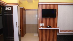 Zona de recepción de un hotel con un mostrador de madera, un televisor de pantalla plana montado en la pared y una puerta con el número 802.