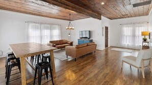 A spacious living area with a wooden dining table, two sofas, a TV, and a lamp. - Birdsong Retreat in McKinney (McKinney)
