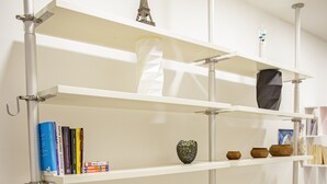 A room with a white desk, two black chairs, and shelves with books and decorative items. - Venezia a 15 min bus sotto casa ogni 10 min, parcheggio libero, animali ammessi. (Chirignago-Zelarino)