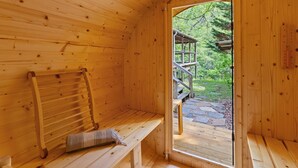A wooden sauna with a bench and a towel rack.