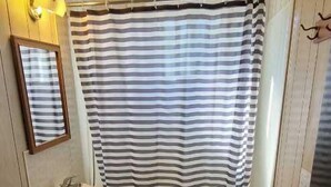 Ein kleines Badezimmer mit Toilette, Waschbecken und Badewanne.