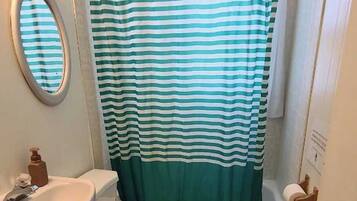 Ein kleines Badezimmer mit Toilette, Waschbecken und Badewanne.
