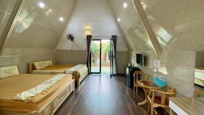 A triangular room with two beds, a wooden table, a TV, and a ceiling fan. -  Homestay Tuyet Anh (Tri Ton)