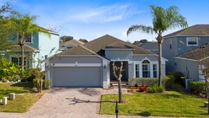 A residential house with a garage, driveway, and well-maintained lawn.