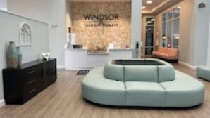 Un intérieur moderne avec un comptoir d’accueil portant l’inscription « Windsor » et un espace détente doté d’un banc incurvé.