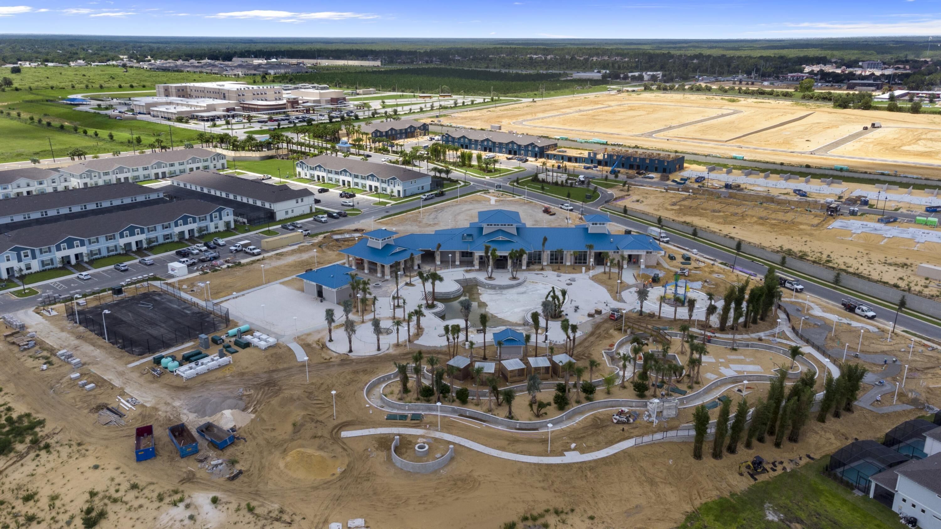 An aerial view of a residential development with multiple buildings, roads, and open spaces.