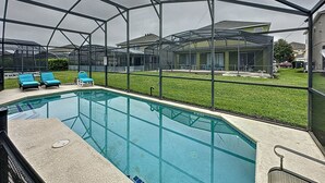 A covered outdoor swimming pool with clear glass walls, surrounded by a metal frame. - 4 Bed 3 Bath in a Gated Community With Pool (Kissimmee)