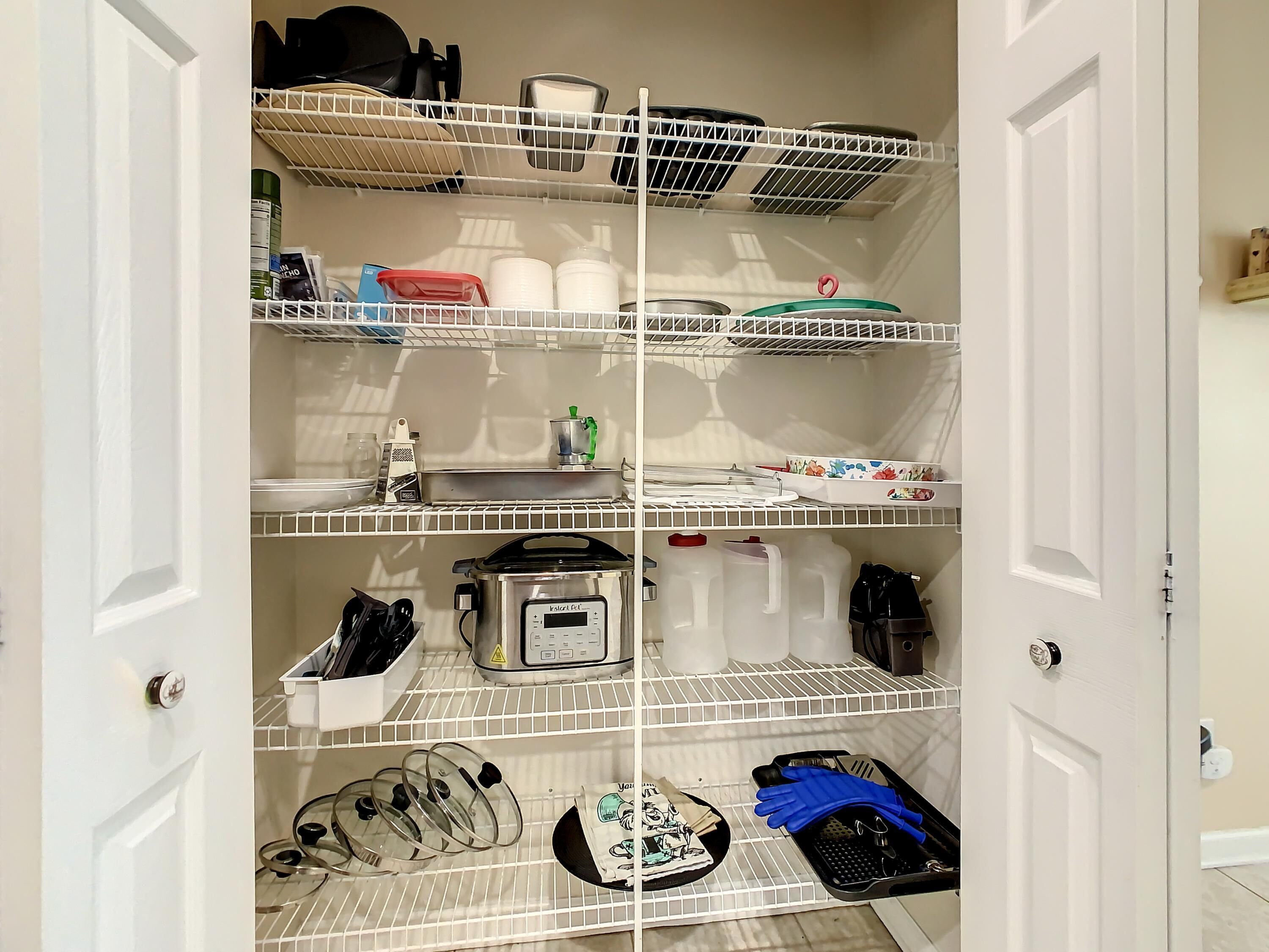 A well-organized pantry with shelves for storage, a coffee maker, and kitchen utensils.