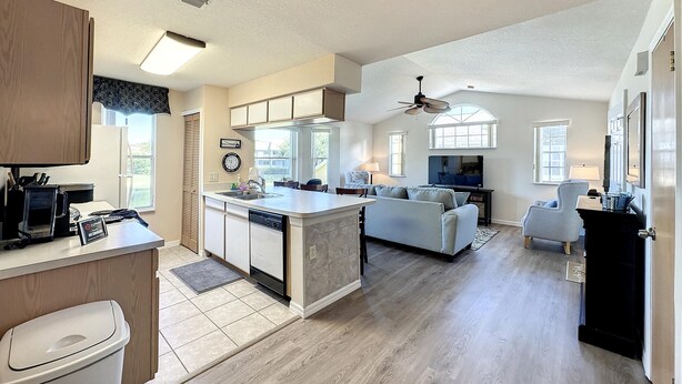 A spacious kitchen with a central island, a dining area with a sofa, and a living room with a TV. - Lovely 3 bed Condo Near Disney Quiet Community (Kissimmee)
