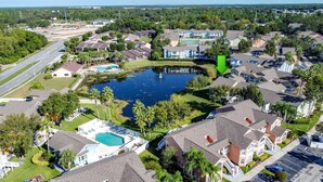 An aerial view of a residential area with houses, a swimming pool, and a pond. - Lovely 3 bed Condo Near Disney Quiet Community (Kissimmee)