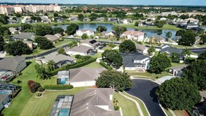An aerial view of a residential area with houses, a lake, and a golf course. - Fantastic 7 Bed 6 Bath in Prestigious Gated Comm (Kissimmee)