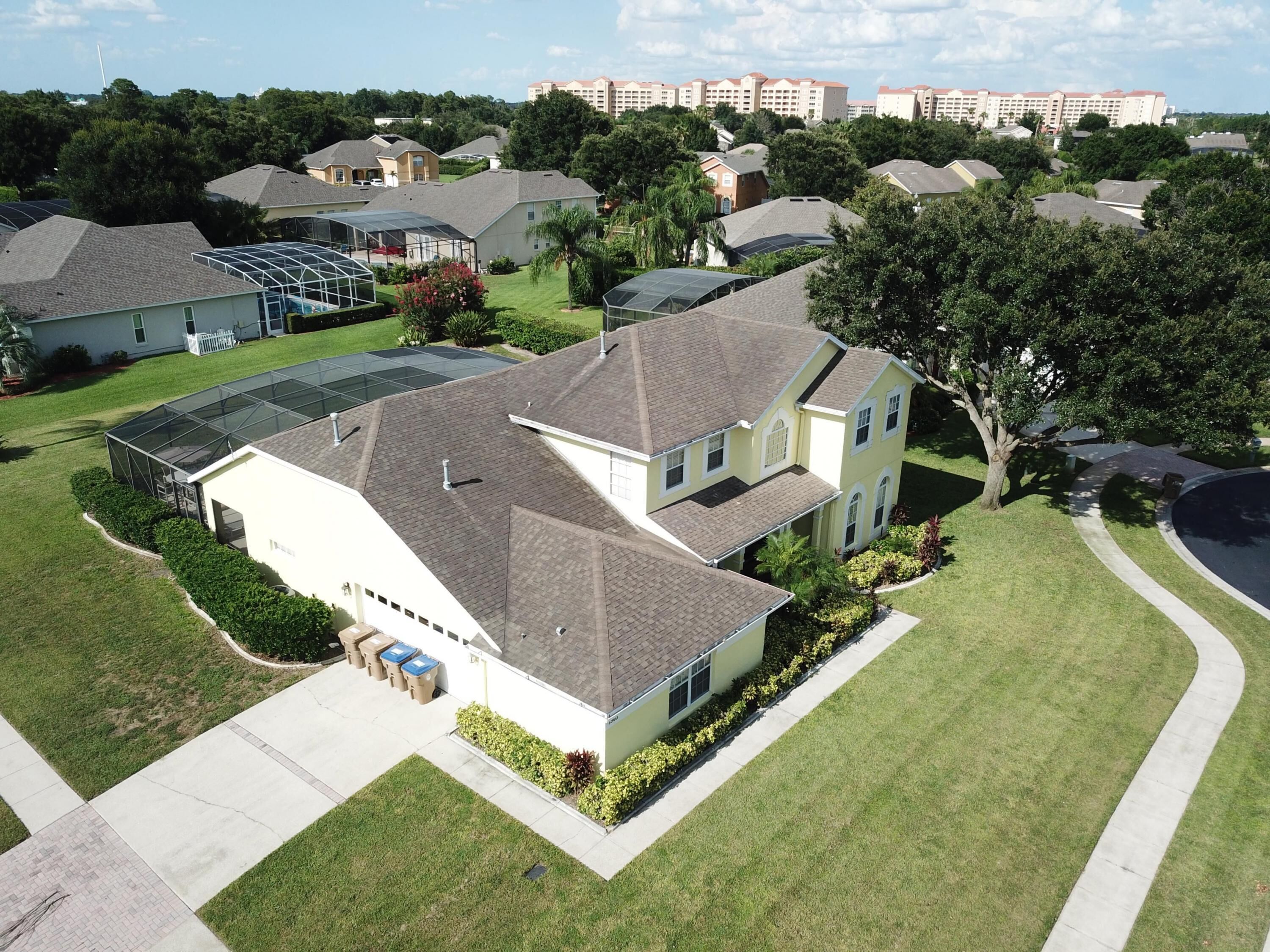 A residential house with a large garage, a covered patio, and a well-maintained lawn.
