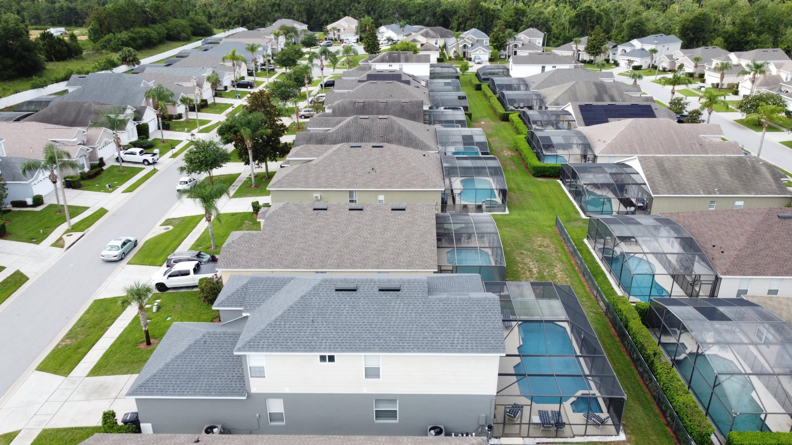 A residential area with modern houses, a swimming pool, and a well-maintained lawn.