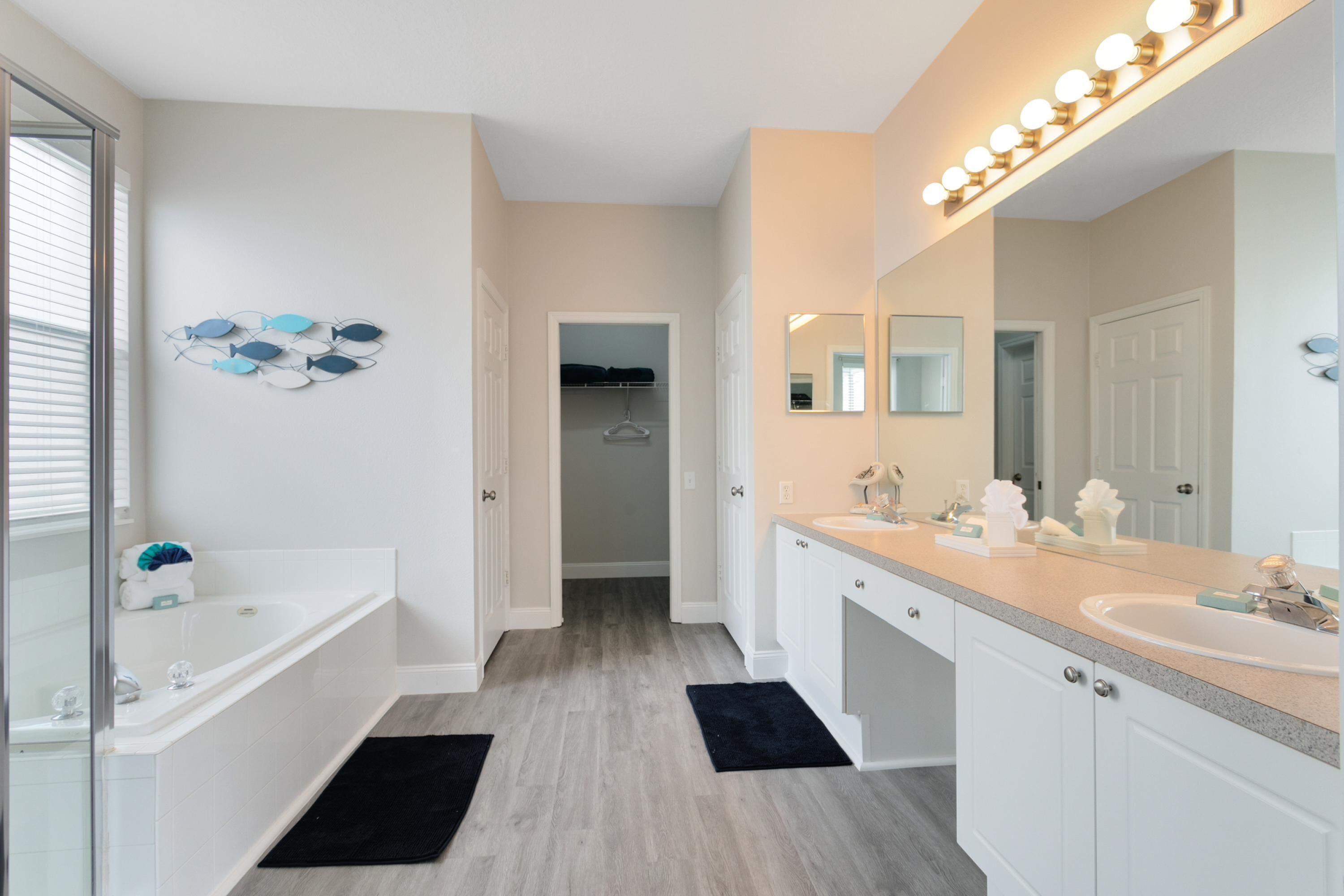 Une salle de bain moderne avec un double vasque, un grand miroir et un dressing.
