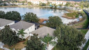 Una zona residencial con casas, un estanque y una calle.