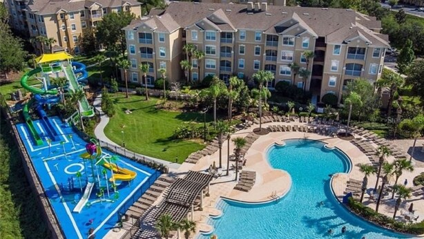 Un resort con una gran piscina, parque acuático y varios edificios de apartamentos.
