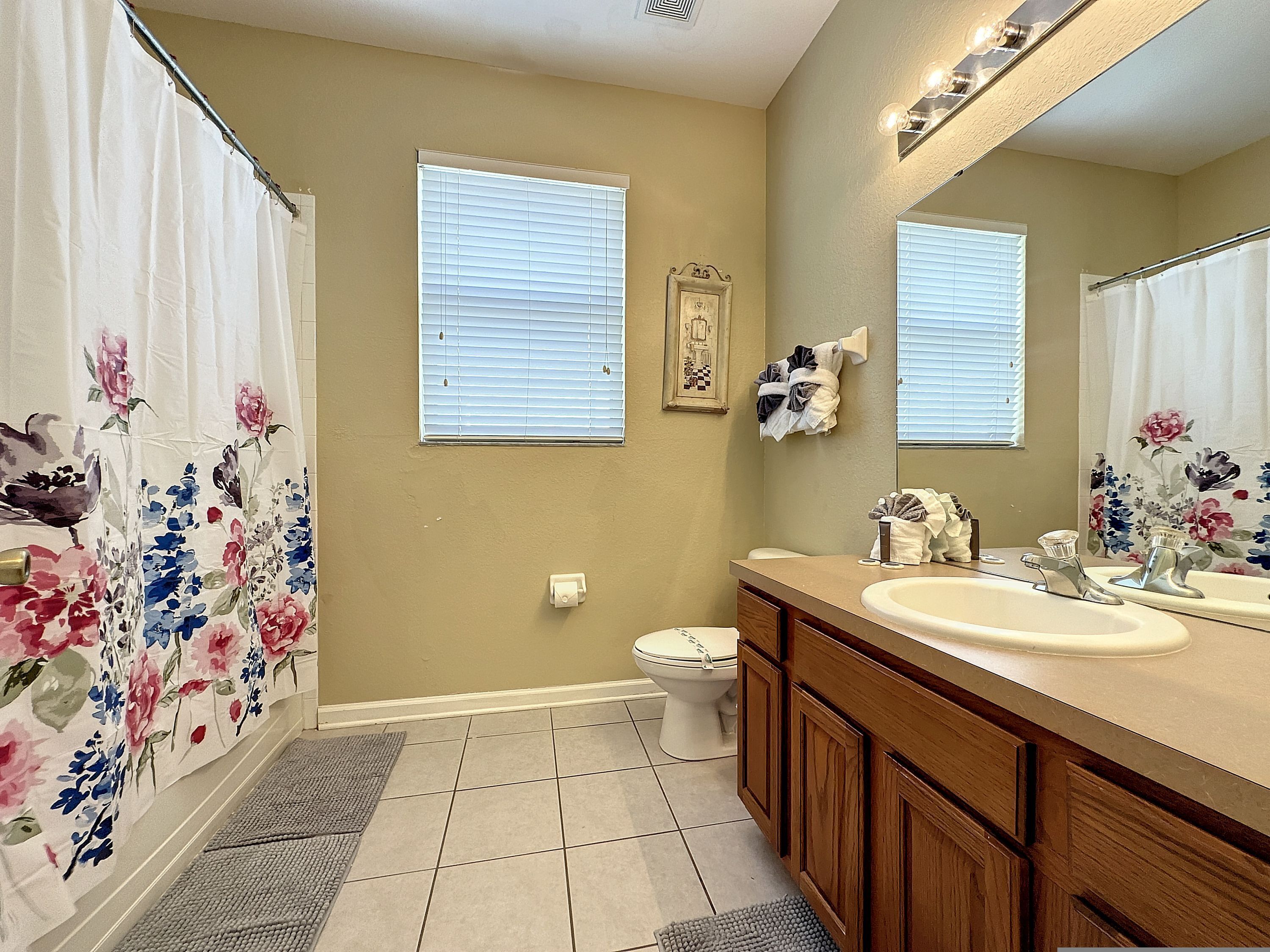 A bathroom with a toilet, sink, and shower area.