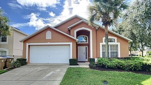 A two-story house with a white garage door, a front entrance, and a well-maintained lawn. - Emerald Island Resort 4 bed 3 Bath With Pool spa (Kissimmee)