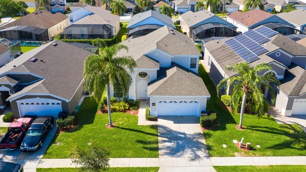 A residential area with houses, solar panels, and a clear view of a lake. - Fantastic Resort 5BR House - South Facing Pool Spa (Kissimmee)