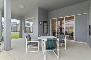 Relax on the patio with a view, surrounded by a comfortable seating area and a glass door leading to the interior.