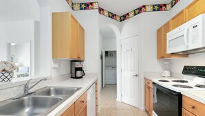 Eine moderne Küche mit Edelstahlgeräten, Holzschränken und einer weißen Arbeitsplatte.