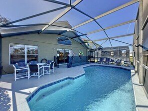 A swimming pool with lounge chairs and a covered patio area. - 4 Bed in Emerald Island Resort Mins to Disney (Kissimmee)