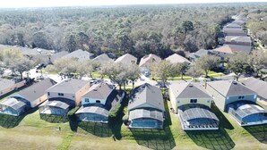 An aerial view of a residential area with houses featuring sloped roofs and a central courtyard.