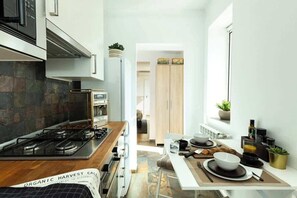 A modern kitchen with a gas stove, oven, and a dining area with a table set for two.