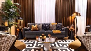 Un salon moderne avec un canapé, une table basse et deux petites tables d’appoint.