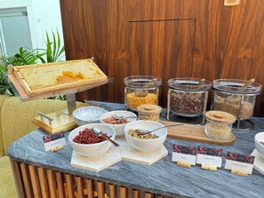 A buffet setup with various food items and containers.