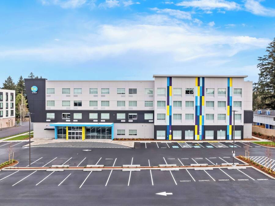 A modern building with a parking lot in front.