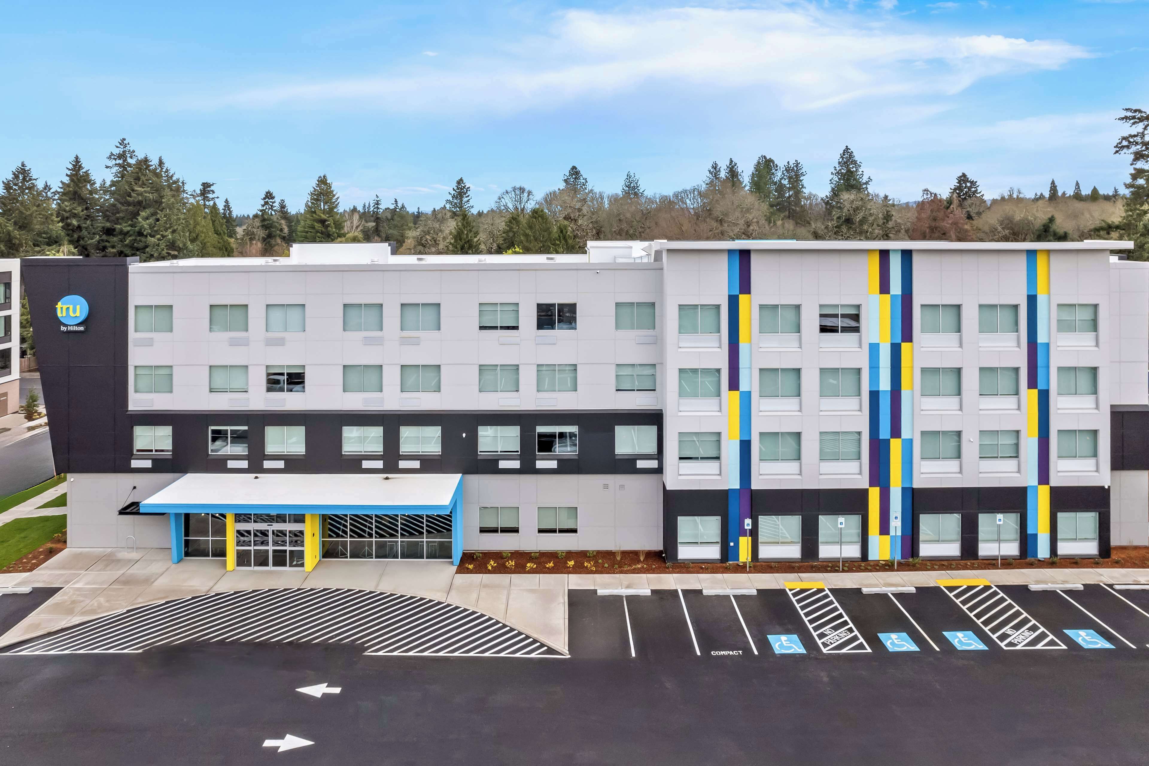 Un bâtiment moderne doté d’un parking et d’une marquise bleue.
