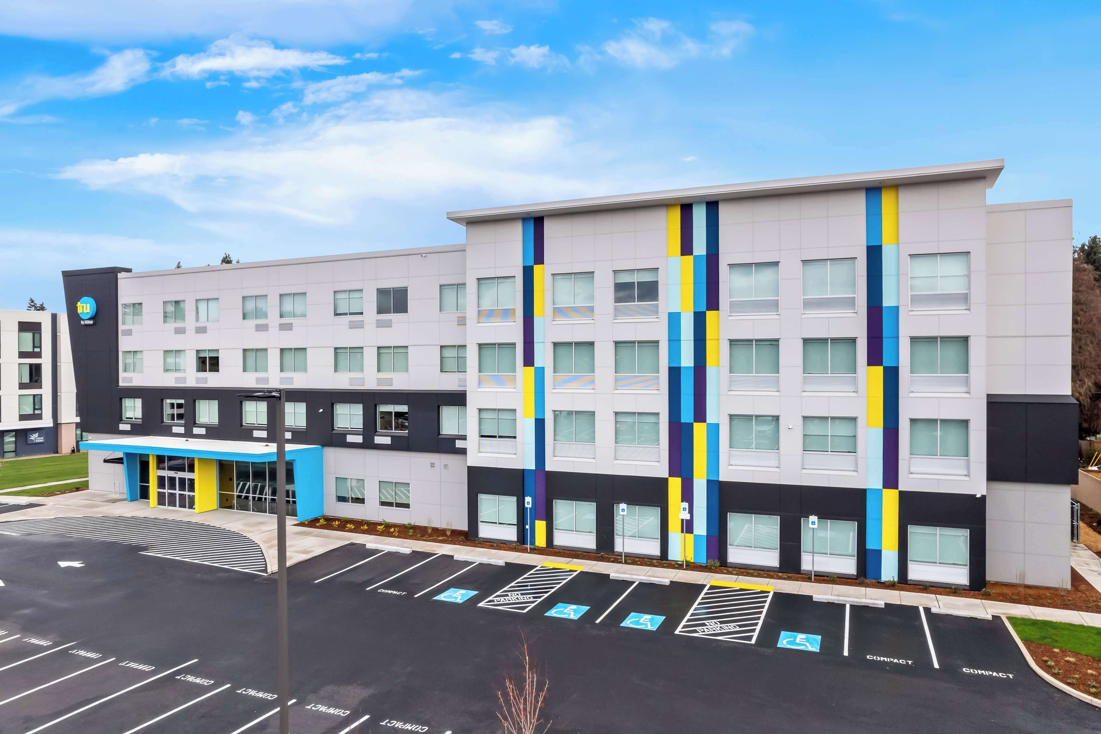 A modern building with a parking lot, marked handicap spaces, and a blue entrance.