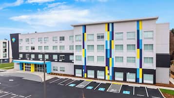 A modern building with a parking lot, marked handicap spaces, and a blue entrance.