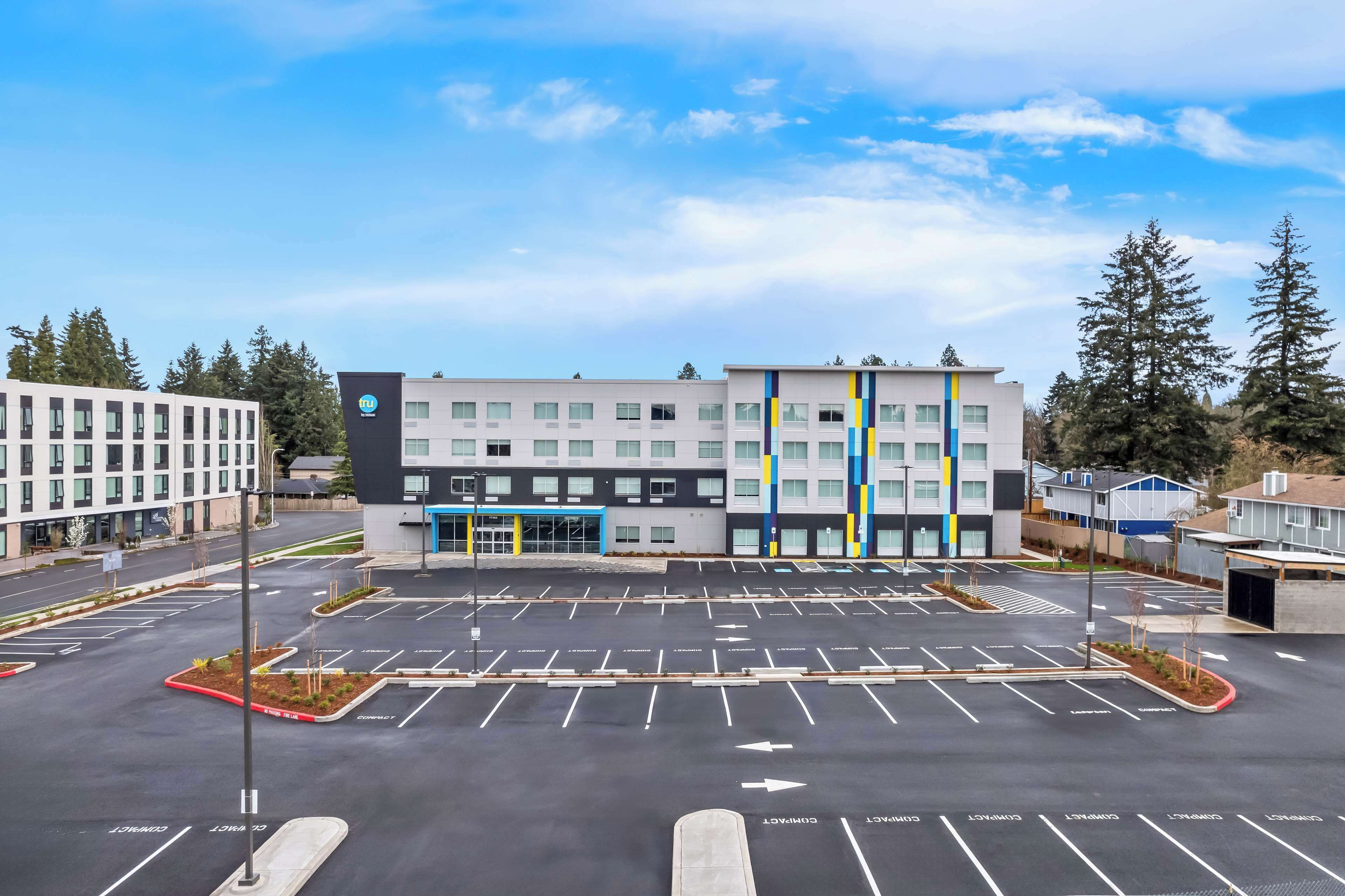 A modern building with a parking lot in front.