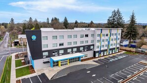 A modern hotel with a flat roof, multiple windows, and a parking lot. - Tru By Hilton Aloha Beaverton (Aloha)