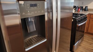 A stainless steel refrigerator with a built-in water dispenser and a freezer compartment. - Kid Friendly Comfy Get Away (Victorville)