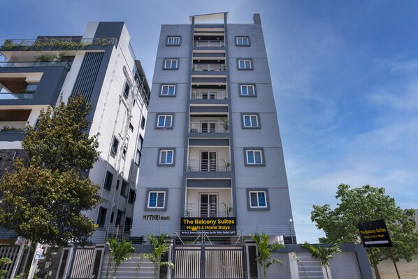 Ein modernes Gebäude mit Balkonen, mit der Aufschrift "The Balcony Suites Hotels & Home Stays".