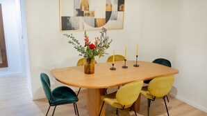 A dining table with a vase of flowers, candles, and four chairs. - Wonderful Apartment near the Vatican and Historical Center (Roma)