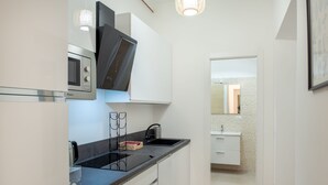 A modern kitchen with a built-in microwave, a kettle, and a sink. - Wonderful Apartment near the Vatican and Historical Center (Roma)