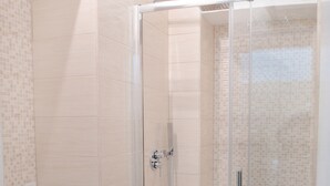 A modern bathroom with a glass-enclosed shower, a toilet, and a sink. - Wonderful Apartment near the Vatican and Historical Center (Roma)