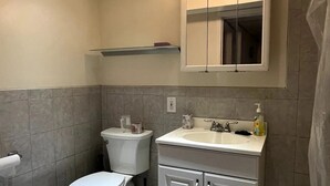 Une salle de bain avec des toilettes, un lavabo et un miroir.