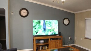 A living room with a television on a wooden stand, a sofa, and a coffee table.