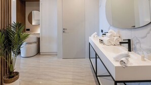 A modern bathroom with a long vanity, a large mirror, and a potted plant. - Studio with direct access to the pool | Villa 5 (Pigeon-Pea Hill)