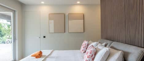 Un dormitorio moderno con una cama grande, una ventana con persianas y dos unidades de aire acondicionado instaladas en la pared.