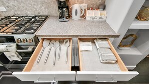 A kitchen with a gas stove, coffee maker, kettle, and a coffee bar setup. - Rammies Exquisite 4BR in Katy (katy)