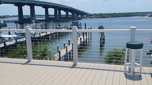Une terrasse en bois offrant une vue sur un pont et sur l’eau.