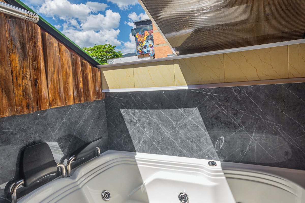Een hottub met een houten terras en uitzicht op de lucht.