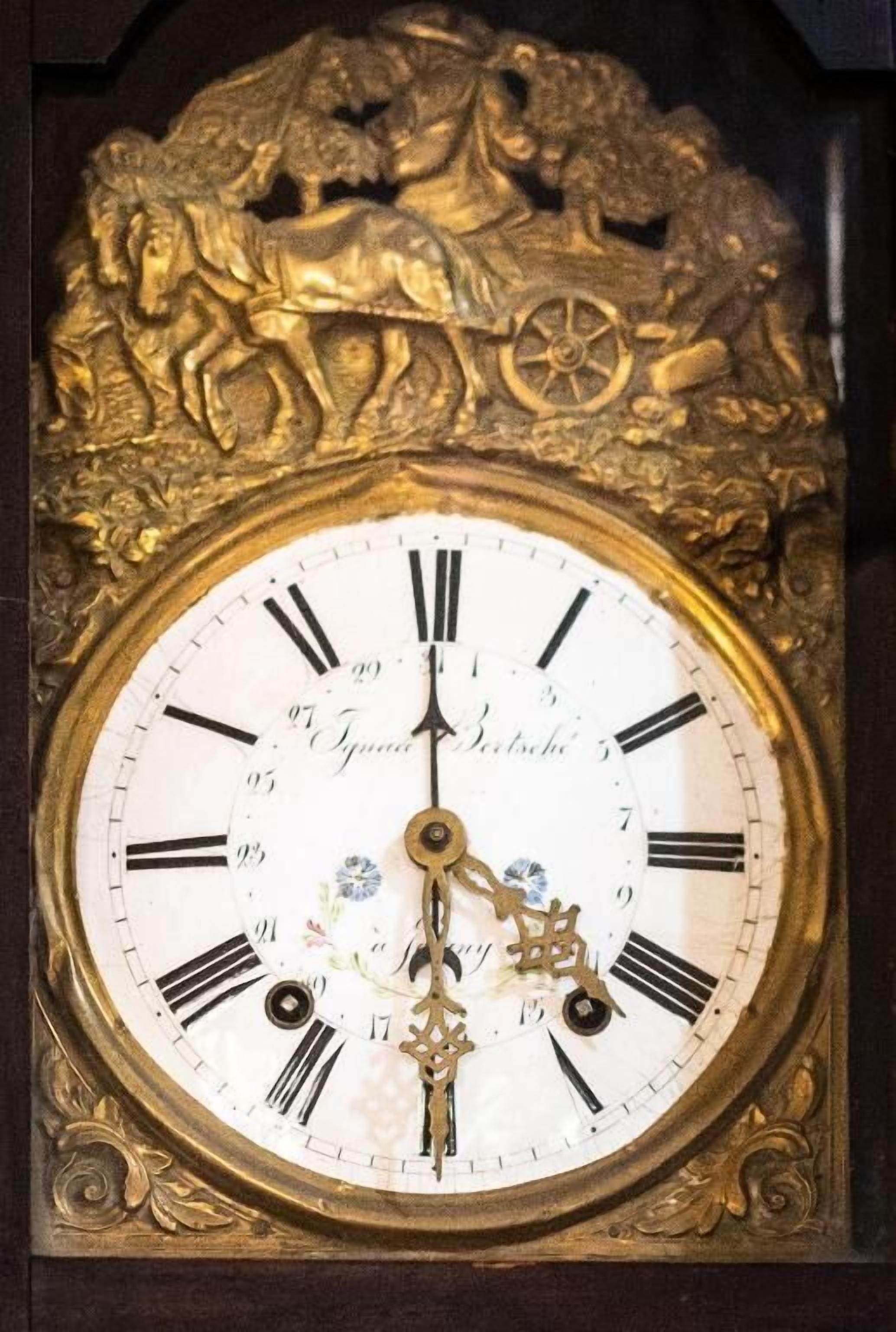 A detailed clock with Roman numerals and a decorative top featuring a horse and rider.