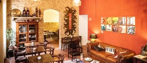 A cozy interior with wooden furniture, a brick wall, and a red accent wall with framed pictures.